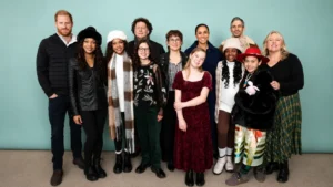 Cast and production team posing together at a Cookie Queens promotional event against a plain studio background.