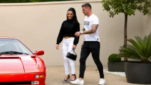 Couple walking beside a red sports car outside a modern home