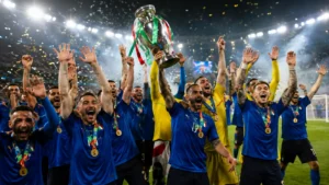 Football players celebrating with a trophy after winning an international tournament.