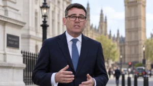 UK politician speaking outdoors near the Houses of Parliament in London.